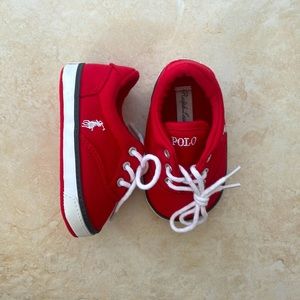 Red size 3 infant polo sneakers with blue and white details.
